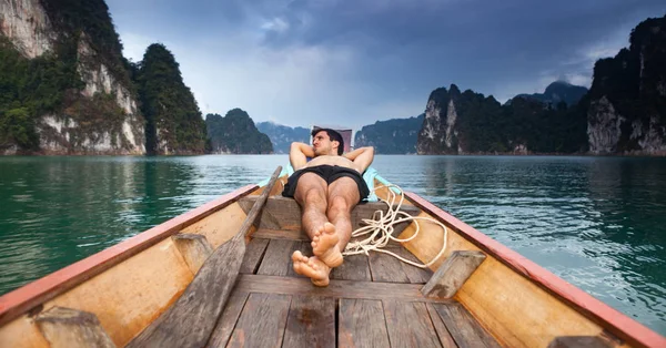 Young man sleeping on the floating boat. — Stock Photo, Image