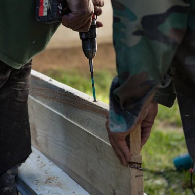 Katılımcıların araçları ve erkek elleri iş yerinde yakın planda.