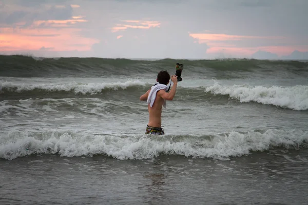 Jeune homme beau posant dans l'eau près de l'océan . — Photo