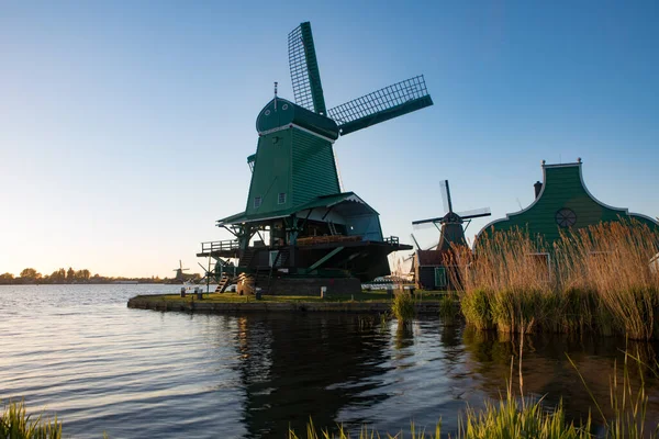 アムステルダム,オランダ- 2017年1月10日:夜の太陽が沈むザンダムのオランダの風車. — ストック写真