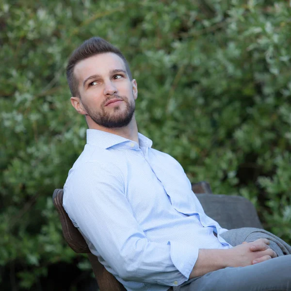 Retrato de un joven elegante hombre guapo posando afuera . —  Fotos de Stock