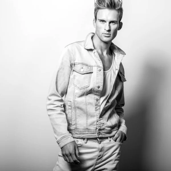 Schöner junger Mann in Jeansjacke. Schwarz-weißes Studioporträt. — Stockfoto