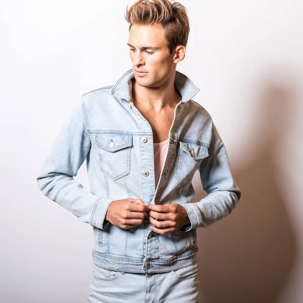 Kot ceket yakışıklı genç adam stüdyoda poz.