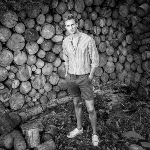Giovane bell'uomo in camicia casual posa vicino sfondo in legno. Foto in bianco e nero . — Foto Stock
