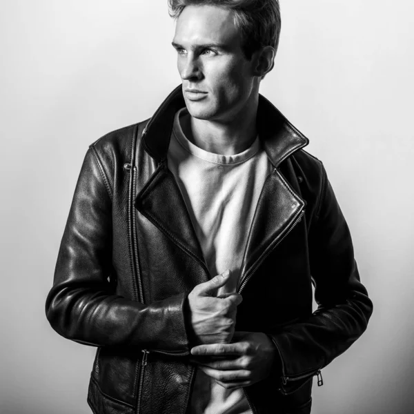 Schöner junger Mann in klassischer Lederjacke. Schwarz-weißes Studioporträt. — Stockfoto