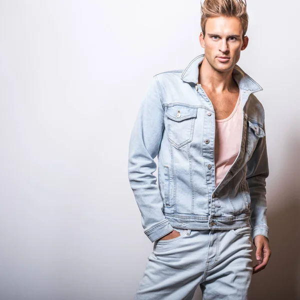 Guapo joven en jeans chaqueta pose en estudio . — Foto de Stock