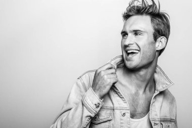 Kot ceketli yakışıklı genç adam. Siyah-beyaz stüdyo portresi.