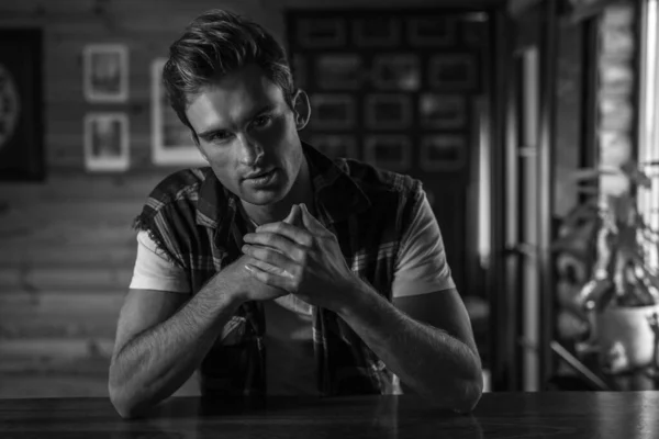 Handsome young man in in casual clothes pose against house interior. Black-white portrait. — Stock Photo, Image