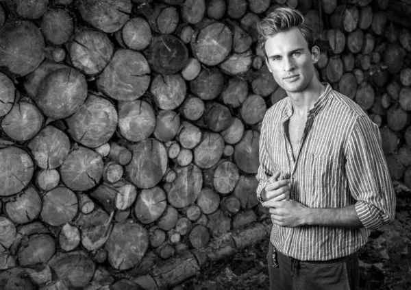 Homem bonito jovem na camisa casual posa perto de fundo de madeira. Foto preto-branco . — Fotografia de Stock