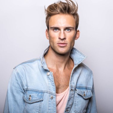 Kot ceket yakışıklı genç adam stüdyoda poz.