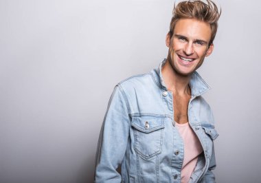 Kot ceket yakışıklı genç adam stüdyoda poz.