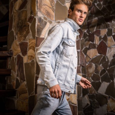 Doğal taş arka plan karşı genç yakışıklı erkek modeli.