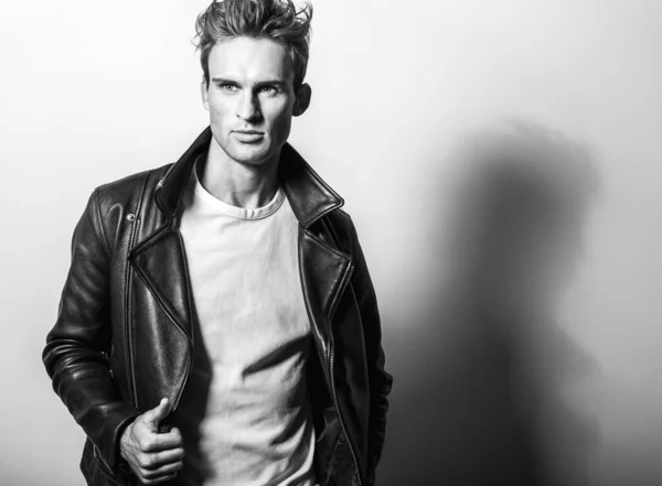 Beau jeune homme en veste classique en cuir. Portrait studio noir-blanc . — Photo