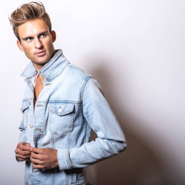 Kot ceket yakışıklı genç adam stüdyoda poz.