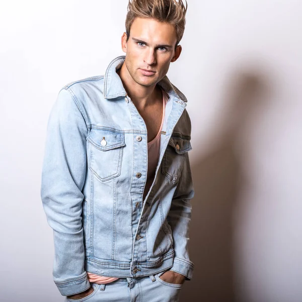 Guapo joven en jeans chaqueta pose en estudio . — Foto de Stock