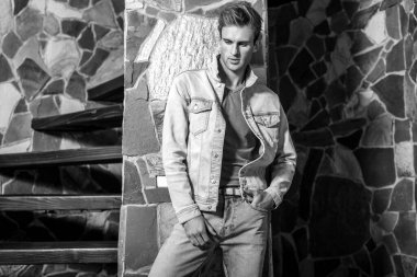 Doğal taş arka plan karşı genç yakışıklı erkek modeli. Siyah-beyaz portre.