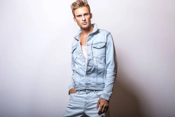 Schöner junger Mann in Jeansjacke posiert im Studio. — Stockfoto
