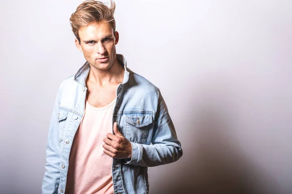 Handsome young man in jeans jacket pose in studio. — Stock Photo, Image