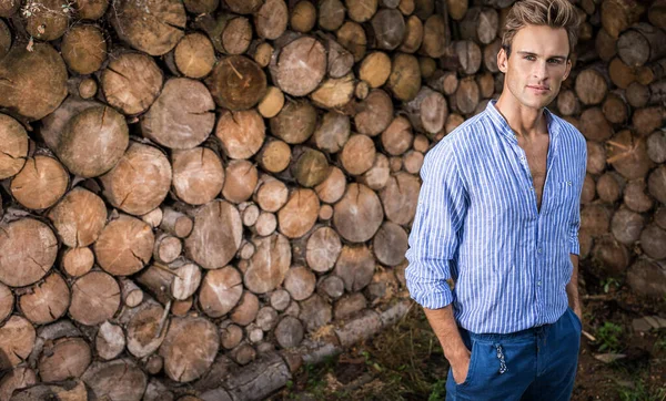 Giovane bell'uomo in camicia casual posa vicino sfondo in legno . — Foto Stock