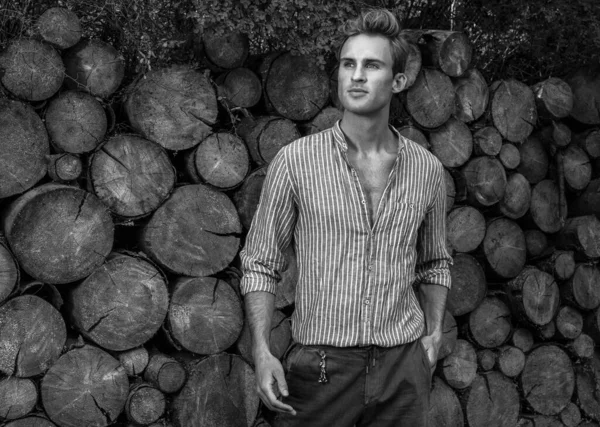 Young handsome man in casual shirt poses near wooden background. Black-white photo. — Stock Photo, Image