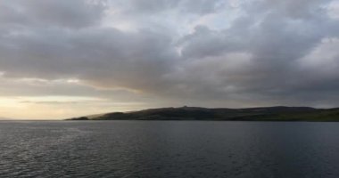 Muhteşem İskoçya güneşinin hareket eden tekneden gökyüzünü örttüğü güzel manzara. 4k Görüntü.