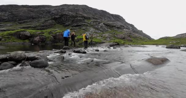 SCOTLAND, REGNO UNITO - 30 MAGGIO 2019: Gruppo di viaggiatori attraversa le pietre nel fiume . — Video Stock