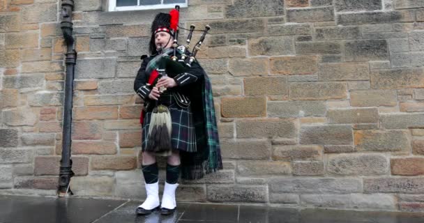 SCOTLAND, UNITED KINGDOM - May 30, 2019: Scottish piper in traditional costume plays on Edinburgh street. 4K Footage . — стоковое видео