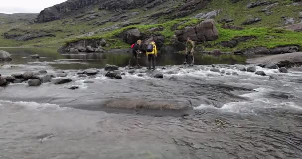 英国苏格兰- 2019年5月30日：一组旅客在河中穿越石块. — 图库视频影像