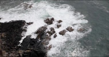 İskoçya 'nın kıyı kayalıklarında dalgalar kırılıyor.