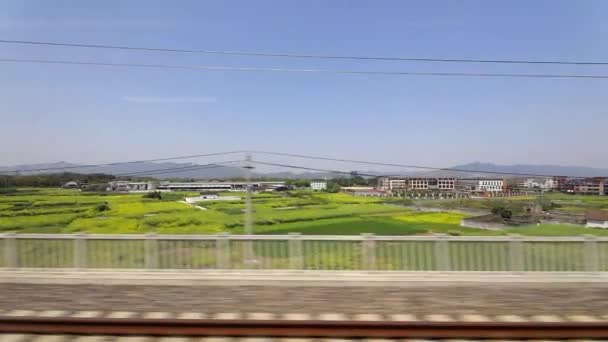 Widok przez okno na prowincje Chin w pociągu dużych prędkości. Filmik o zwolnionym tempie. — Wideo stockowe