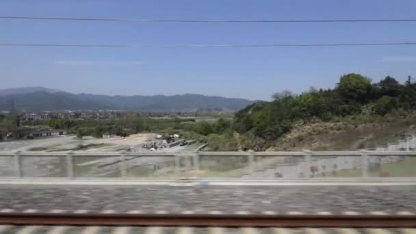 Widok przez okno na prowincje Chin w pociągu dużych prędkości. Filmik o zwolnionym tempie. — Wideo stockowe