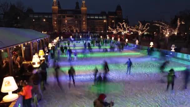 La gente patina en la pista de patinaje sobre hielo de invierno frente al Rijksmuseum, un destino turístico popular. HD Time Lapse 3 en 1 . — Vídeos de Stock