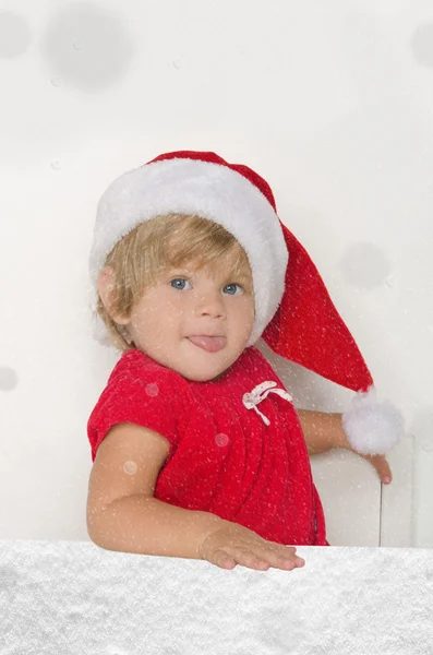 Klein meisje in Santa pak in dalende sneeuw — Stockfoto