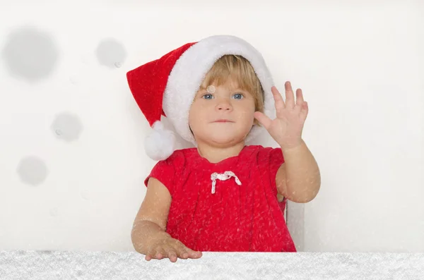 Pequeno bebê vestido como Papai Noel sob a neve caindo — Fotografia de Stock