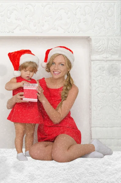 Gelukkig moeder en dochter verkleed als Santa met cadeau, sneeuw — Stockfoto