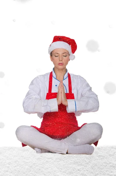 Chef in hat of Santa doing yoga with snow — Stock Photo, Image