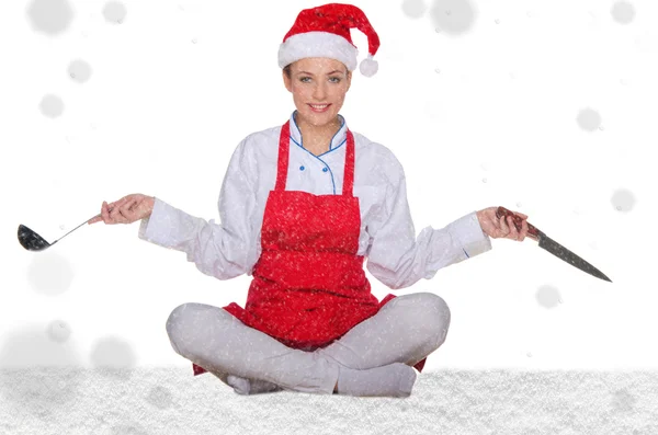 Cook in Santa hat, yoga, knives and snow — Stock Photo, Image