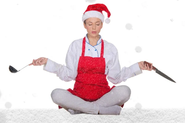 Cook in Santa Claus hat, yoga, knives and snow — Stock Photo, Image