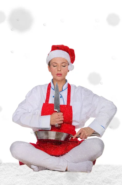 Woman cook in Santa hat, yoga, knife under snow — Stock Photo, Image