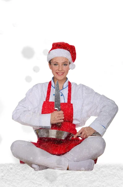 Mujer cocinera en Santa Claus sombrero, yoga, cuchillo bajo la nieve —  Fotos de Stock