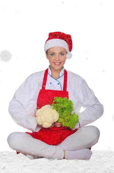 Chef en chapeau de Père Noël, yoga, légumes sous la neige — Photo