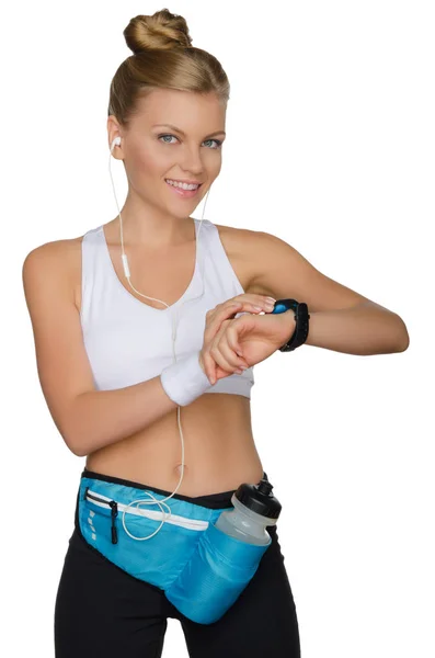 Sonriente mujer deportiva controla su salud mientras hace ejercicio — Foto de Stock