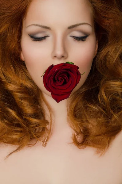 Rose dans les dents de la femme aux cheveux longs — Photo