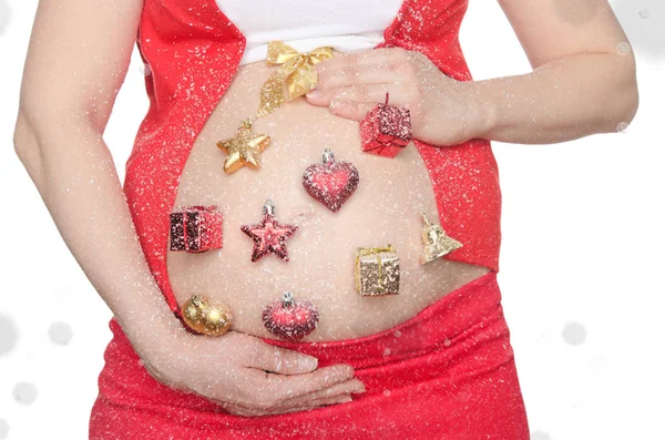 Pancia di donna incinta con decorazioni natalizie — Foto Stock