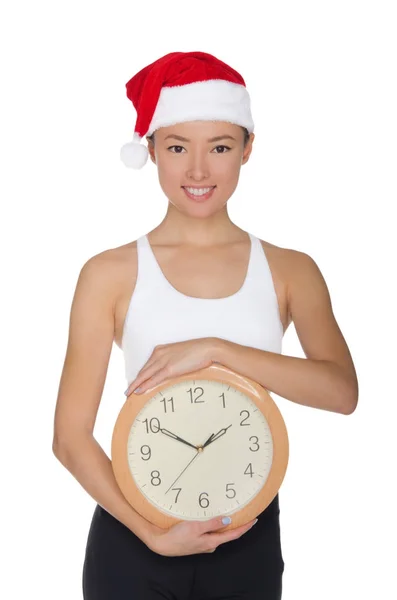 Smukke asiatiske kvinder i en julemandens hat med et ur - Stock-foto