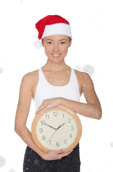 Aziatische vrouwen in een kerstmuts met een klok — Stockfoto