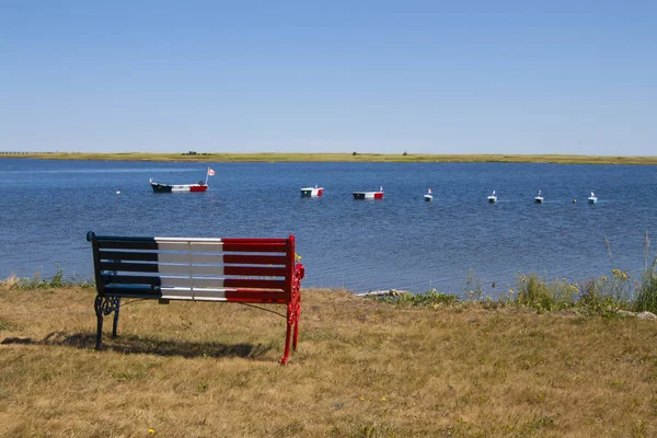 Banco e barcos com bandeira acadiana francesa em Bouctouche, New Brun — Fotografia de Stock