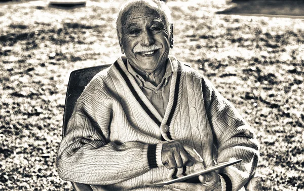 Ouderling senior gelukkig in de tuin met behulp van Tablet PC — Stockfoto