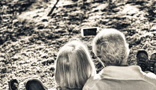 Casal aposentado fazendo uma selfie em um jardim. Felicidade e união — Fotografia de Stock