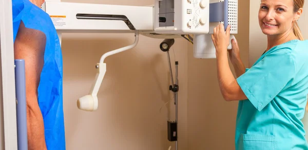 Paciente masculino en la máquina de rayos X con médico femenino —  Fotos de Stock
